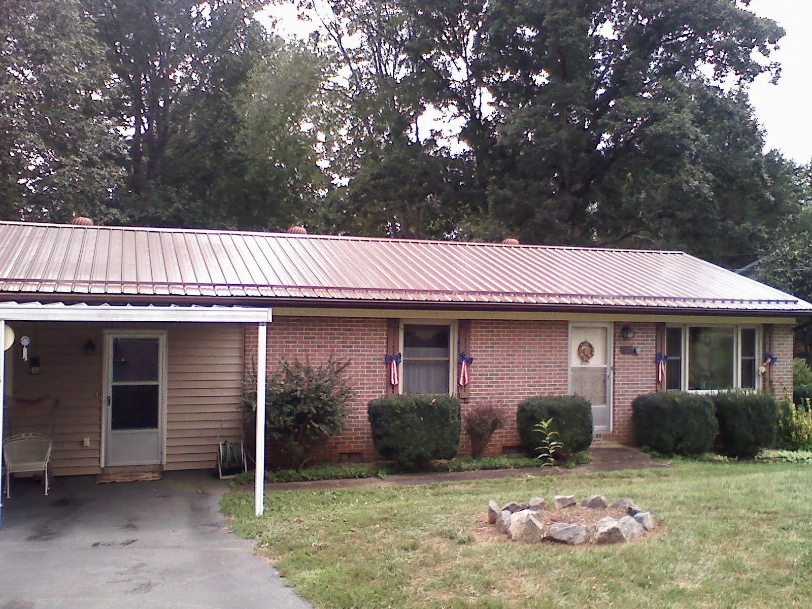 Bronze metal roof and carport on a brick ranch home — Roof Repair work by our crew in Garfield